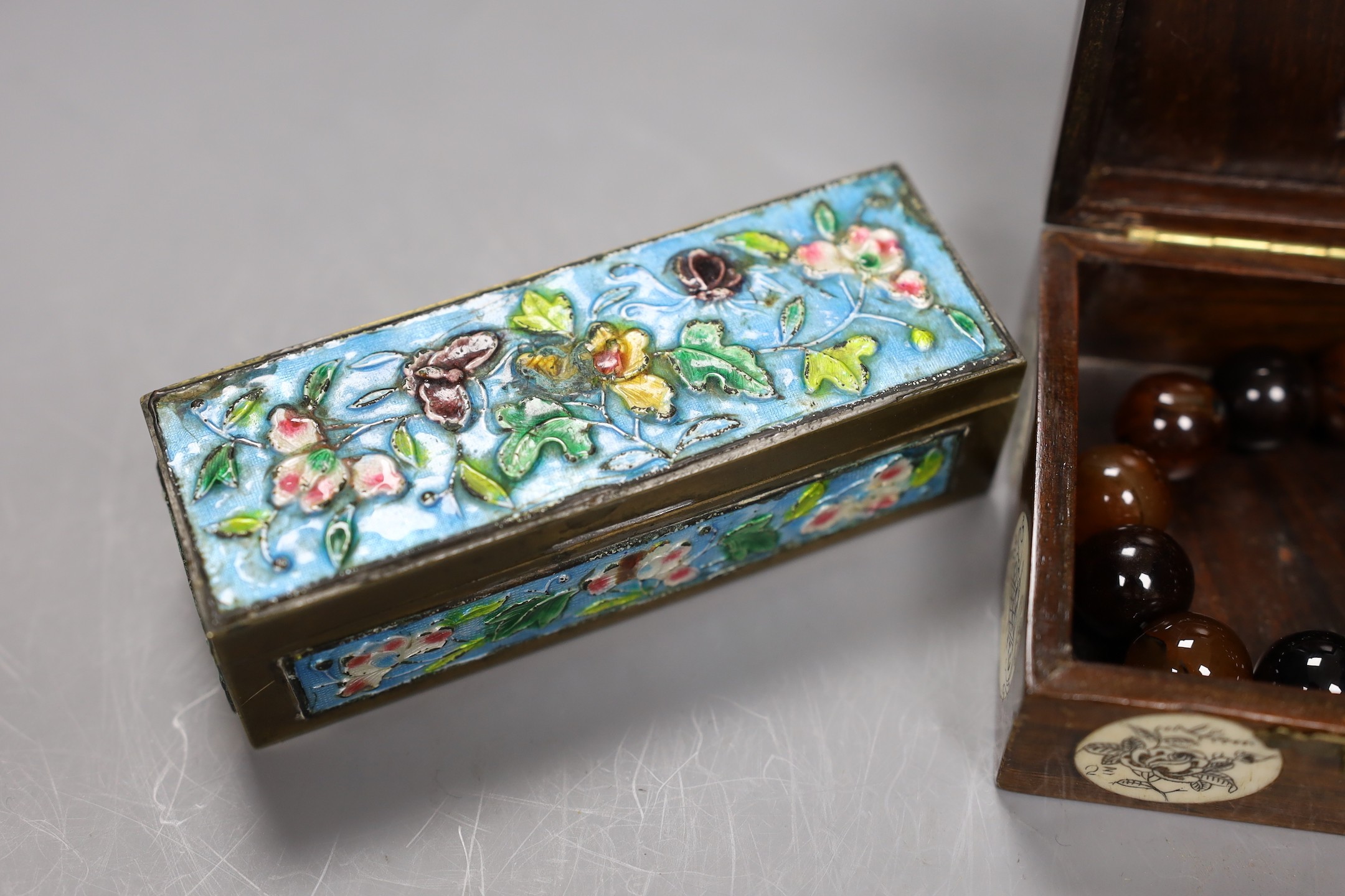 A Chinese enamel on brass stamp box, a Tibetan amulet, an agate bead rosary and a bone inlaid box and cover, enamel box, 11cms x 3.5cms high (4)